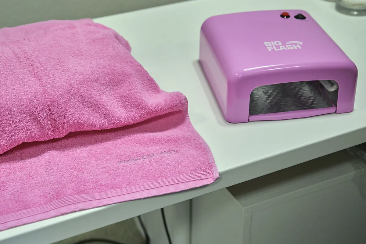 Manicure-Platz mit rosa Handtüchern und UV-Lampe